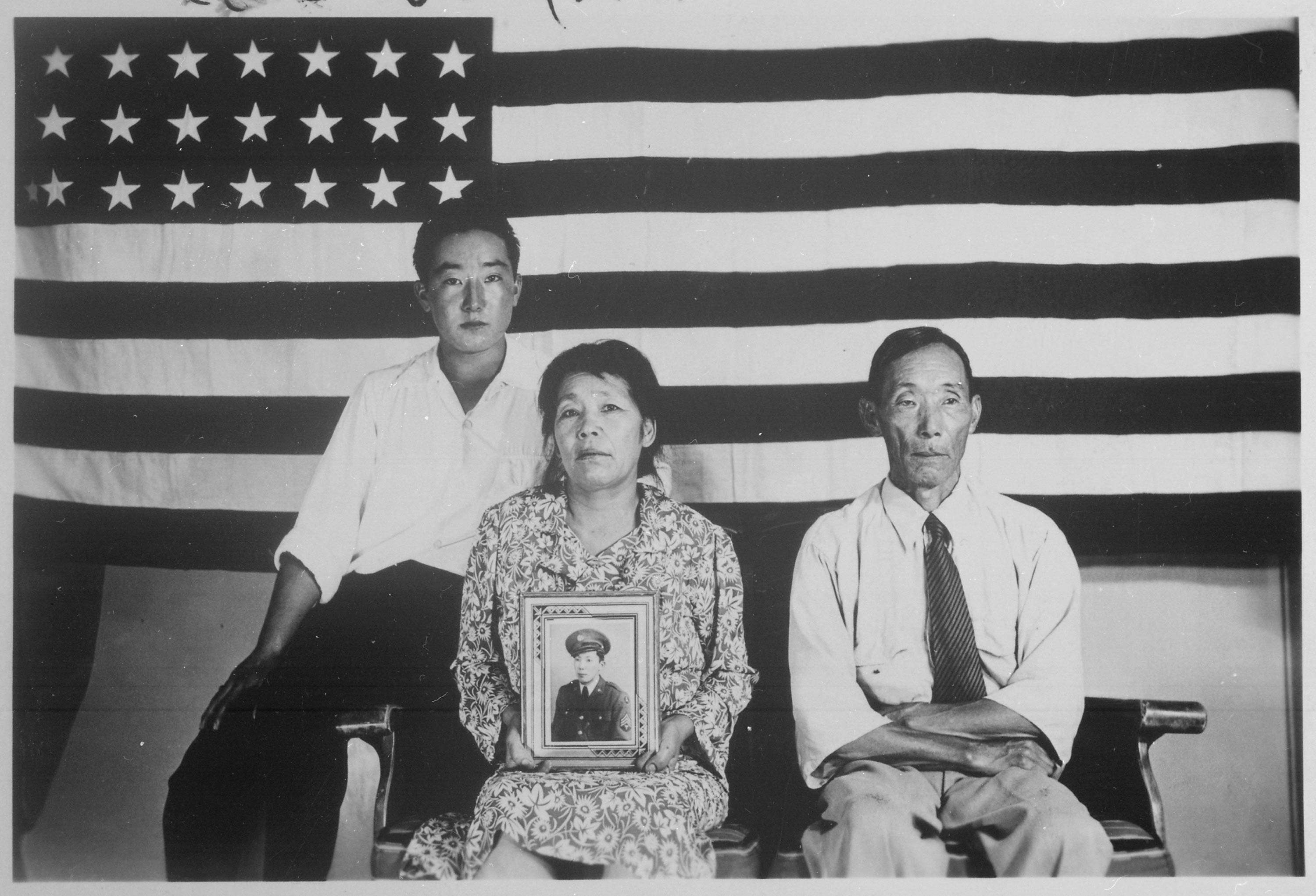 Hirano family pose in front of an American flag