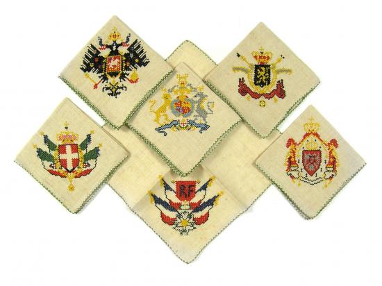 Five embroidered napkins with European coats of arms