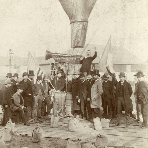 A group of people by what appears to be a hot-air balloon. 