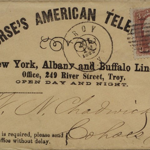 an envelope that reads "Morse's American Tele" from an office in Troy, NY. The paper is faded and has cursive writing on it.